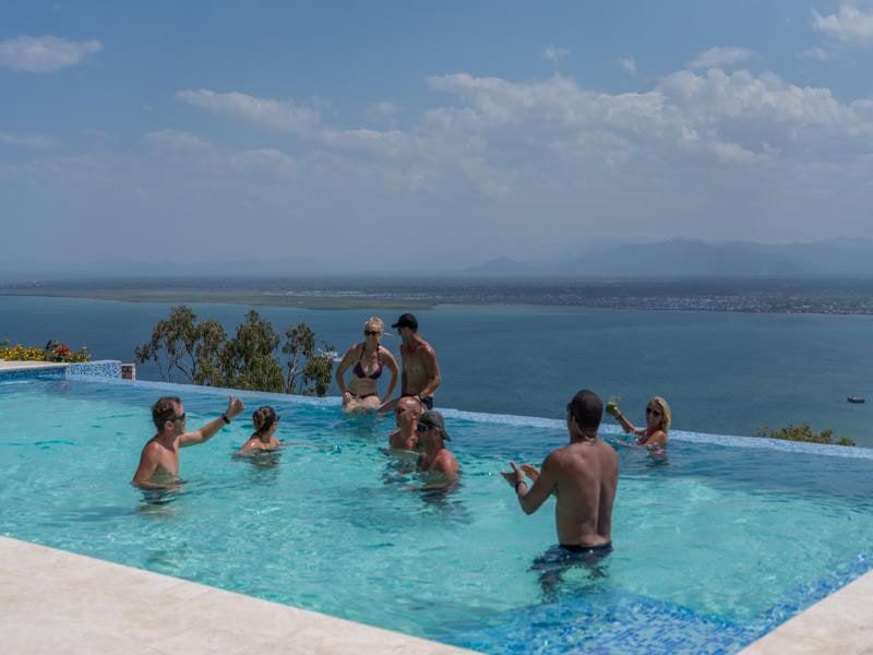 Guests in the infinity pool above the bay
