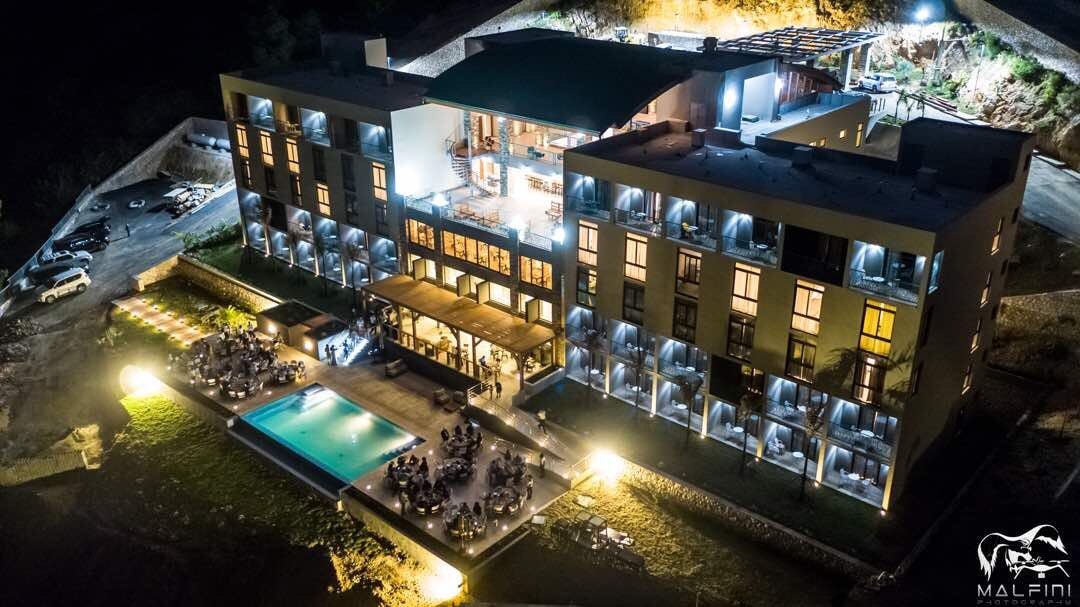 Satama Hotel at night, with the pool and terrace lit up